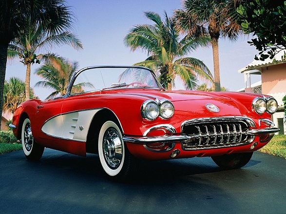 A Red Chevrolet Corvette In Front Of Palms
