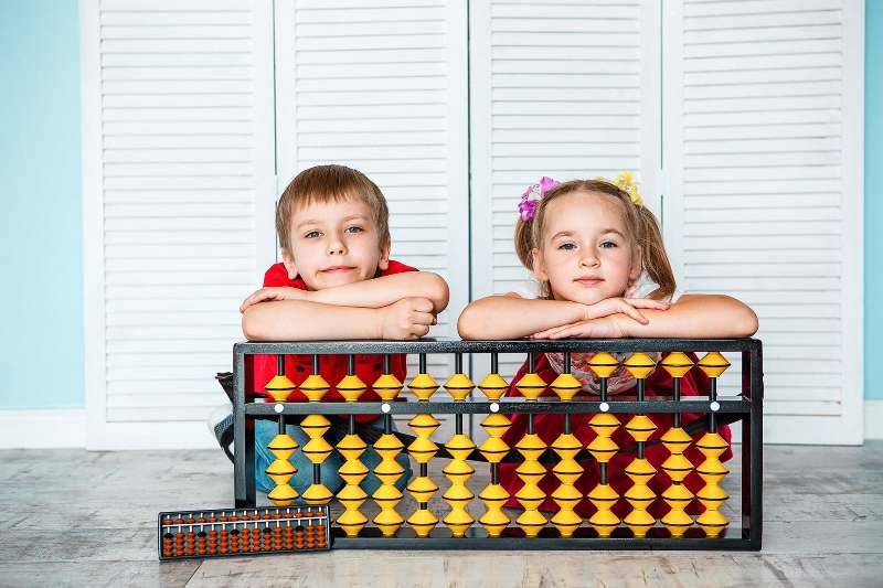 Boy And A Girl With An Abacus At School