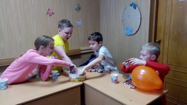 Children Sharing Sweets From A Box In Classroom