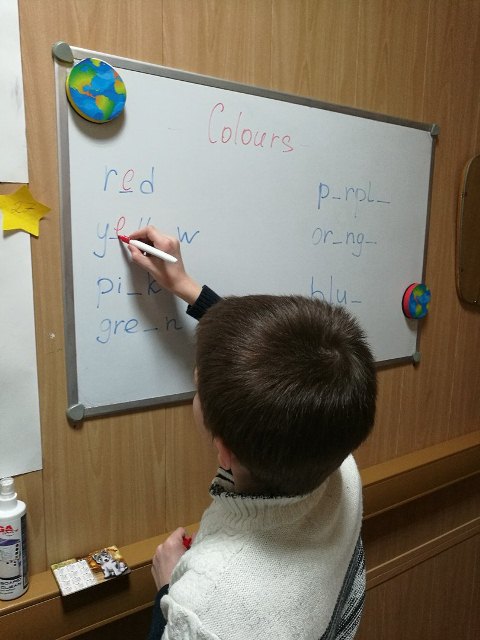 Pupil In Classroom Writing Colours In English On The Board