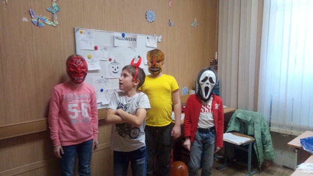 Pupils Wearing Halloween Masks In Front Of The Blackboard