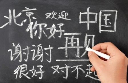 Writing Chinese Characters With A White Chalk On The Blackboard