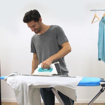 Man Ironing His Shirt On The Ironing Board         